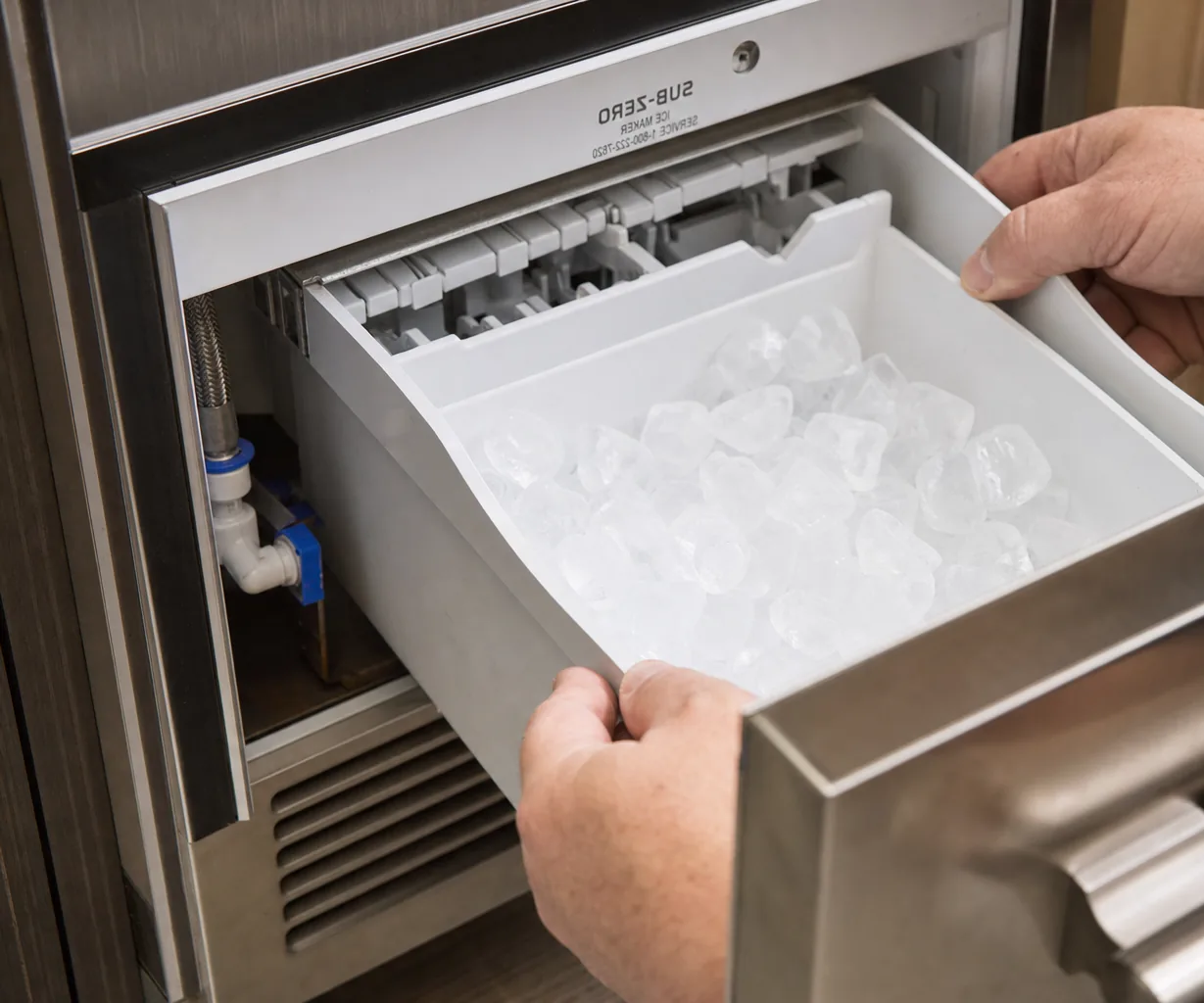 Technician servicing a built-in ice maker mid-repair